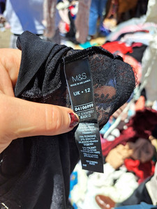 Ein Label an einem weggeworfenen Kleidungsstück der Marke M&S