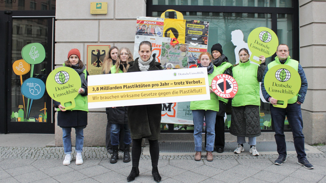 Eine Personengruppe mit Schildern der Deutschen Umwelthilfe, die sich gegen die Plastikflut wehren.