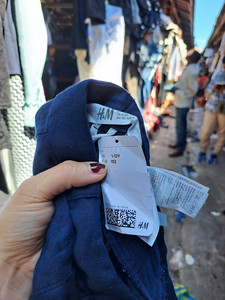 Ein Label an einem weggeworfenen Kleidungsstück der Marke H&M